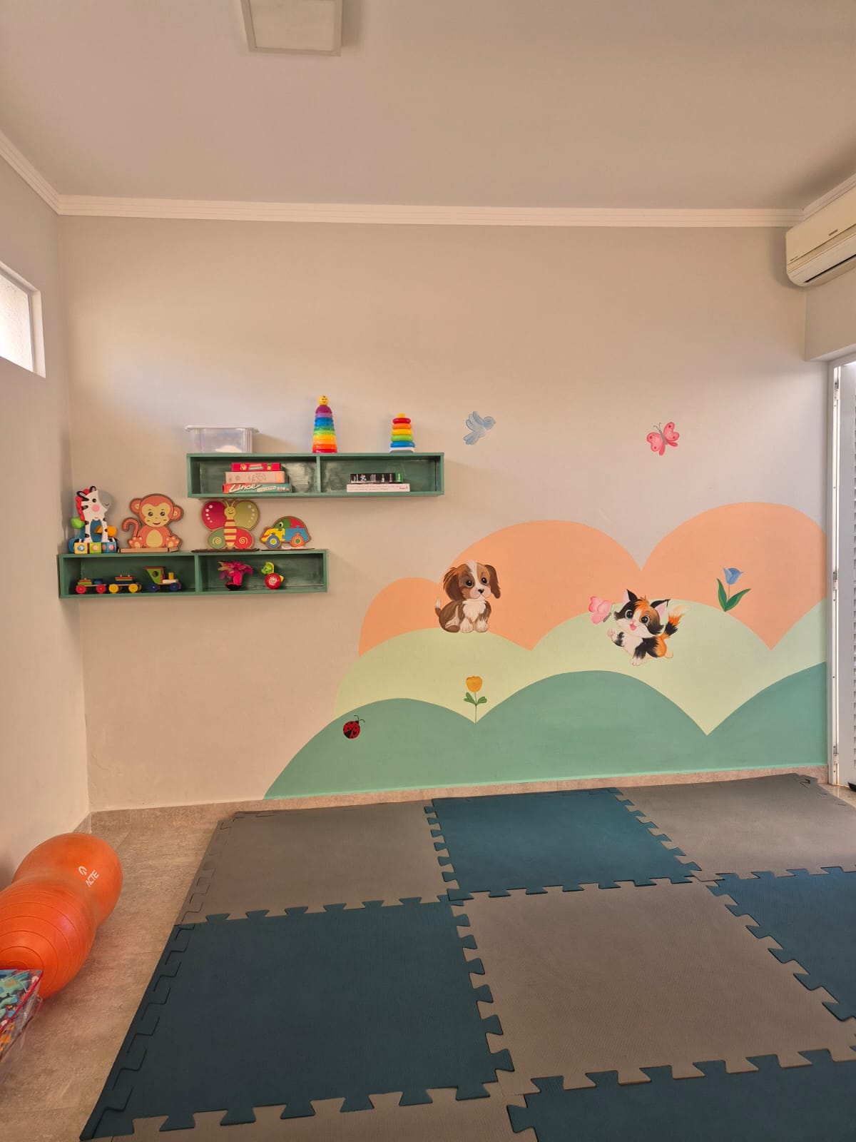 Sala de estimulação infantil com tapete e brinquedos